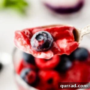 spoonful of yogurt slushie with a blueberry and raspberry puree