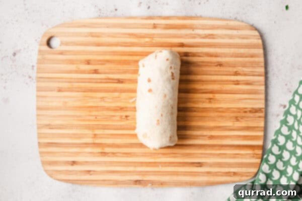 Restaurant-Quality Chipotle Steak Burrito at Home 10 rolled up burrito on cutting board