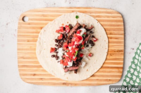 Restaurant-Quality Chipotle Steak Burrito at Home 9 sliced grilled steak, rice, beans, and pico de gallo on flour tortilla