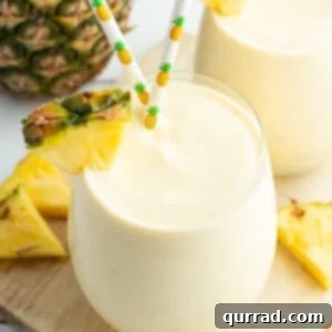 pineapple smoothie with pineapple wedge and straws