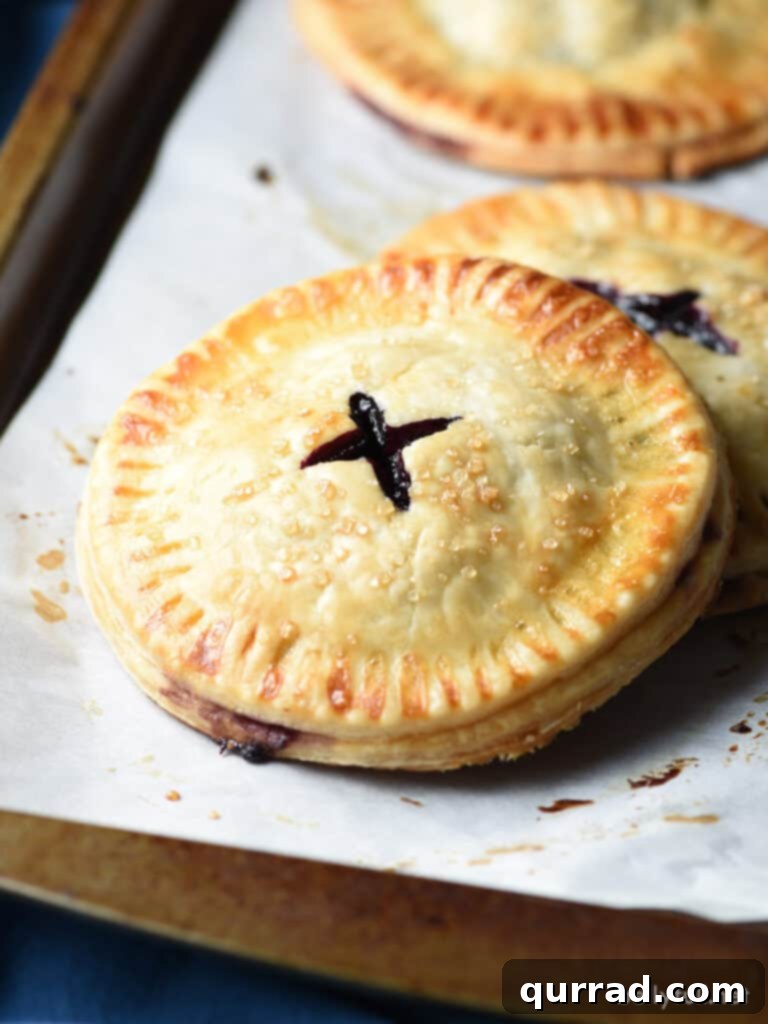 Sweet Blueberry Handheld Treats 3 mini fruit pie on parchment lined baking sheet