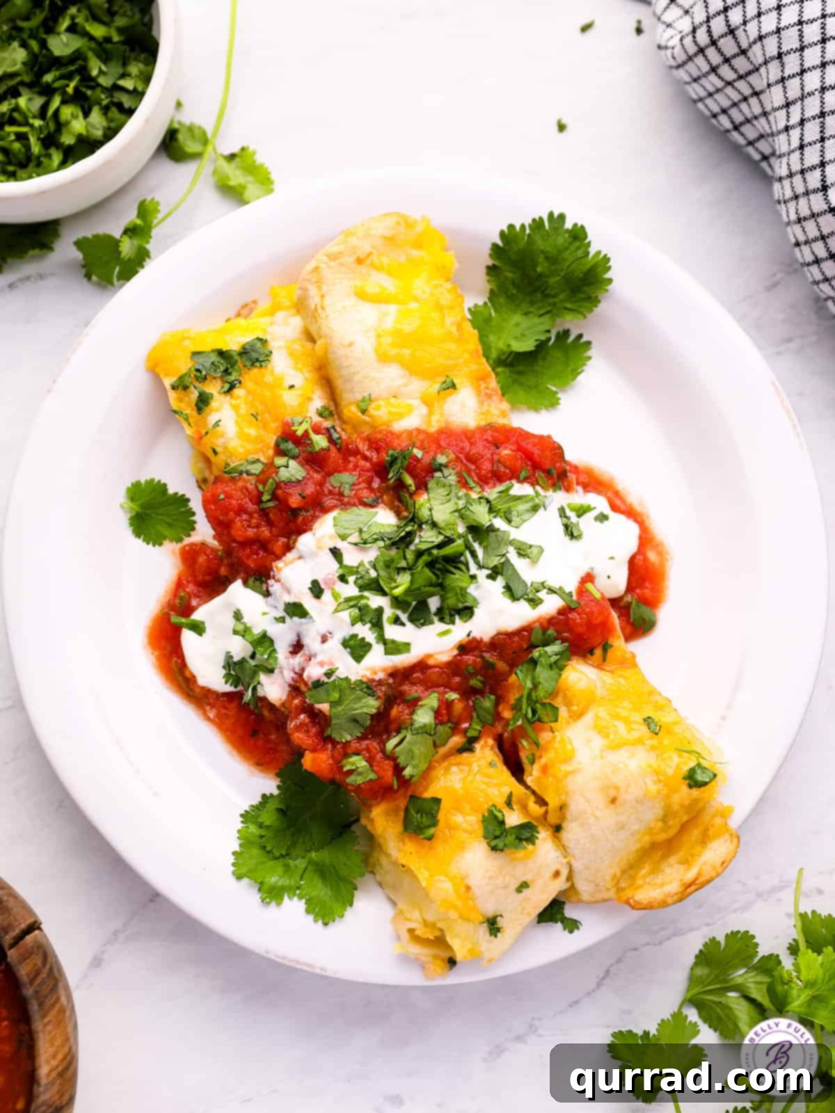 Overnight Breakfast Enchiladas 4 2 enchiladas with sour cream and salsa on plate