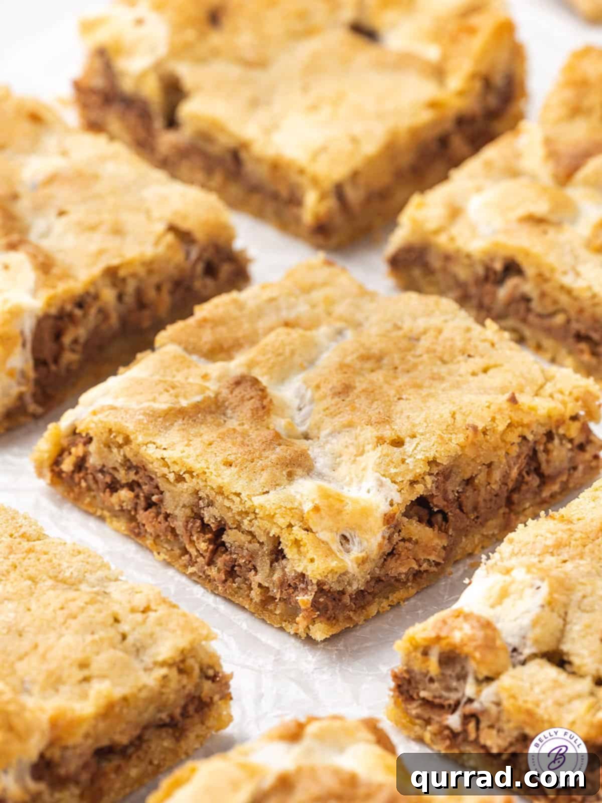 Kit-Kat S'mores Dream Bars 5 A single Kit Kat S'mores dessert bar resting on a piece of parchment paper, highlighting its delicious layers and texture.