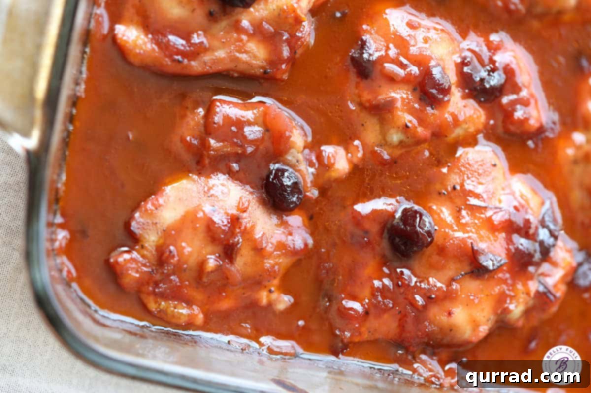 Cranberry Glazed Chicken 5 A close-up shot of the finished baked cranberry chicken still in the casserole dish, bubbling with rich sauce, ready to be served.