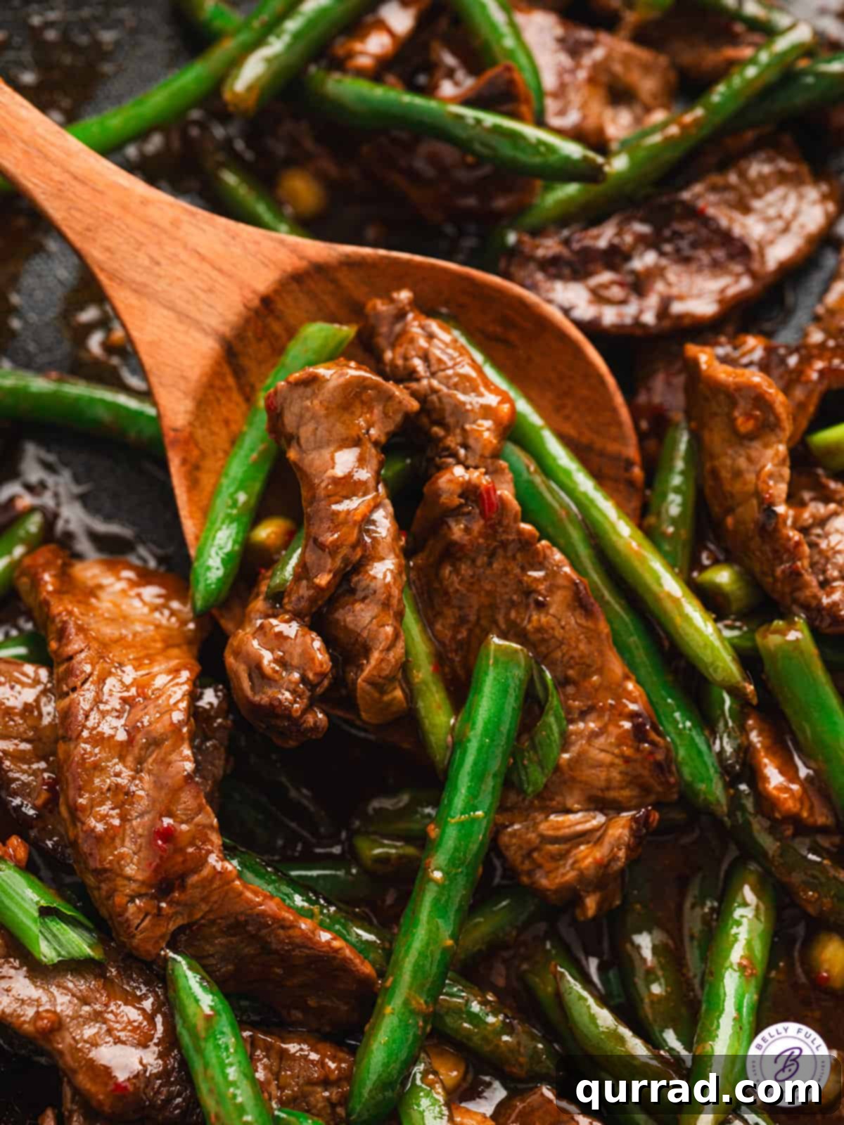 close up beef and green bean stir fry on serving spoon