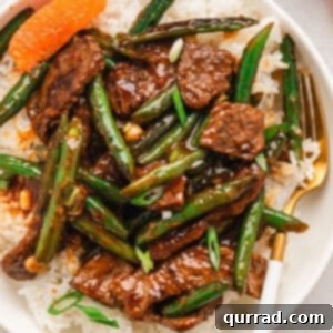 overhead orange beef stir fry over cooked white rice