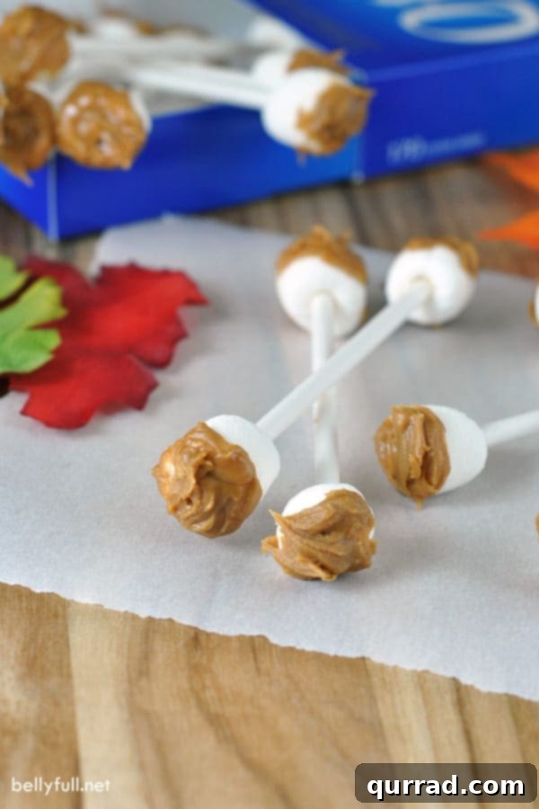 Edible Earwax Swabs - A close-up of the hilarious and easy no-bake Halloween treat, featuring mini marshmallows and Biscoff spread on lollipop sticks.