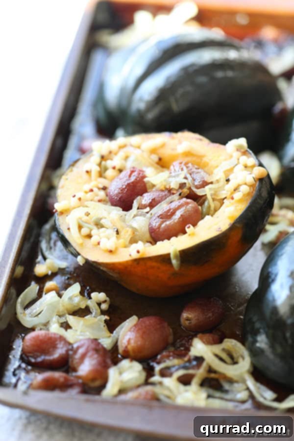 This Stuffed Acorn Squash has that wow factor! Filled with grains, roasted grapes, and caramelized onions, it's a flavor explosion in every bite! #acornsquashrecipes #roastedacornsquash #stuffedacornsquash Roasted Acorn Squash on with grapes and onions