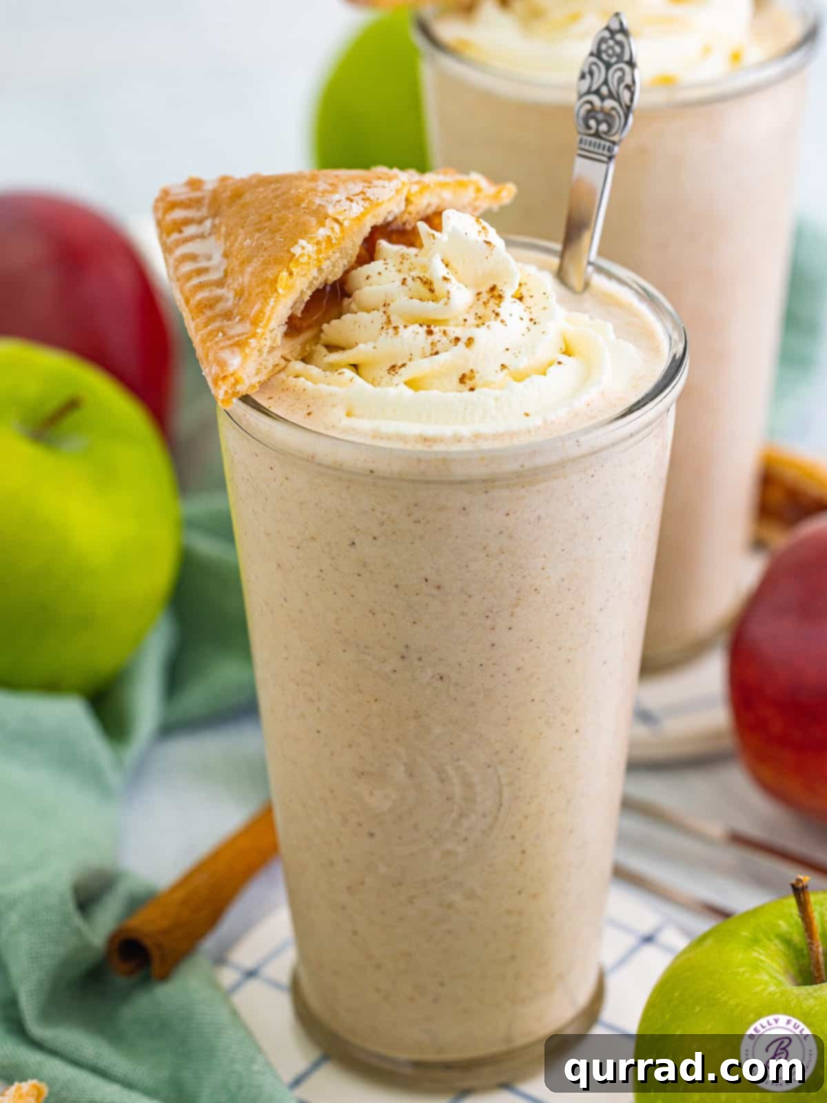 Thanksgiving Leftovers Reinvented 9 A tall glass of creamy apple pie milkshake, generously topped with whipped cream and a small slice of apple pie for garnish.
