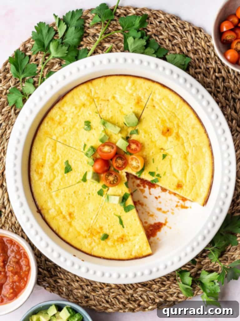 Overhead view of a thick Mexican Omelet Pie garnished with cherry tomatoes, sliced into wedges.