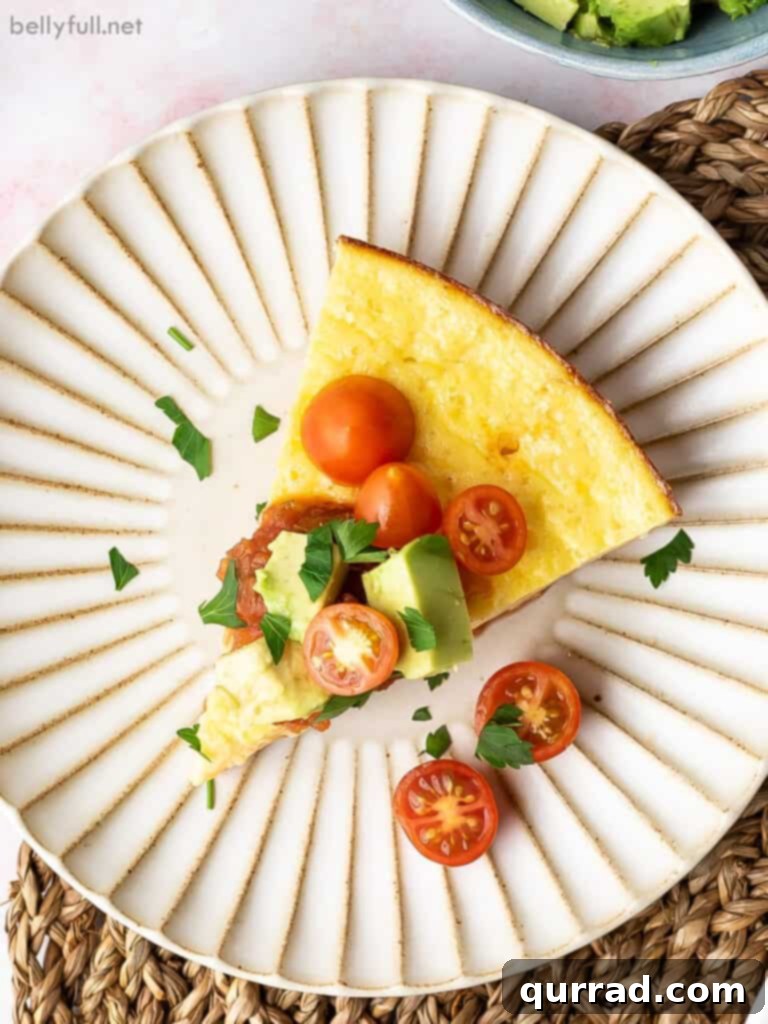 A perfectly baked slice of Mexican Omelet Pie on a plate, garnished with fresh cherry tomatoes.