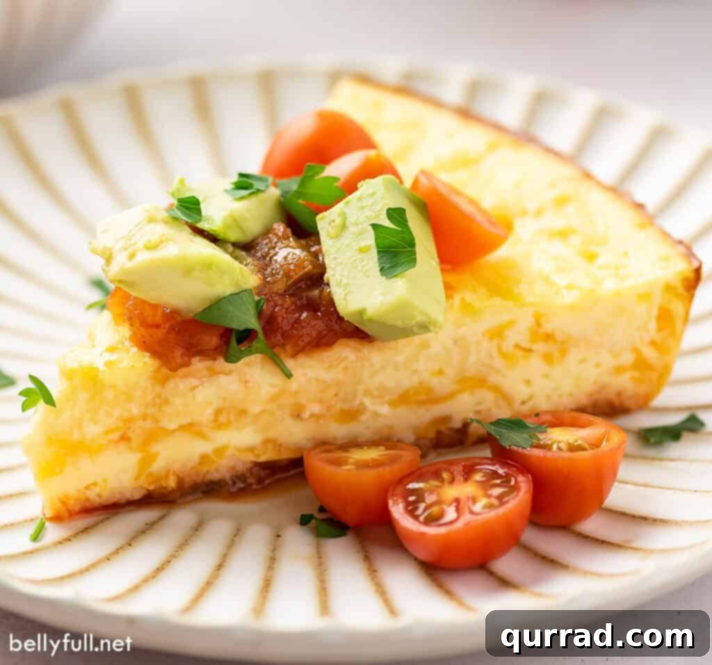 A vibrant slice of Mexican Omelet Pie on a plate, beautifully garnished with cherry tomatoes and avocado.