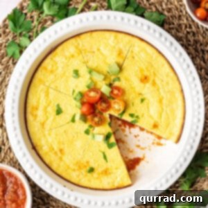 Overhead view of a thick Mexican Omelet Pie with cherry tomatoes, sliced into wedges.