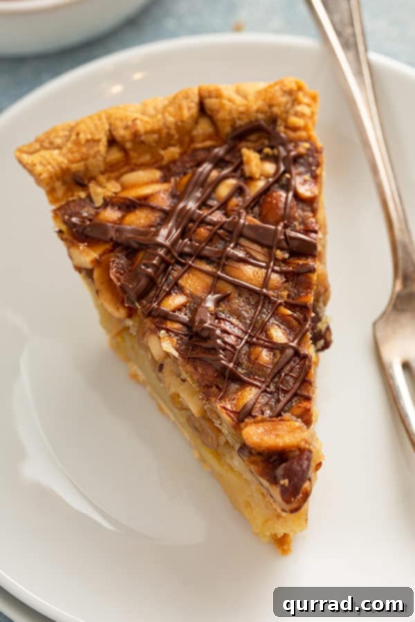 A beautifully presented close-up slice of homemade Turtle Pie, highlighting its inviting layers of custard, nuts, and chocolate topping.