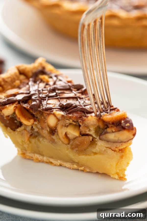 Side angle view of a delicious slice of Chocolate Turtle Pie with a fork, ready to be enjoyed.