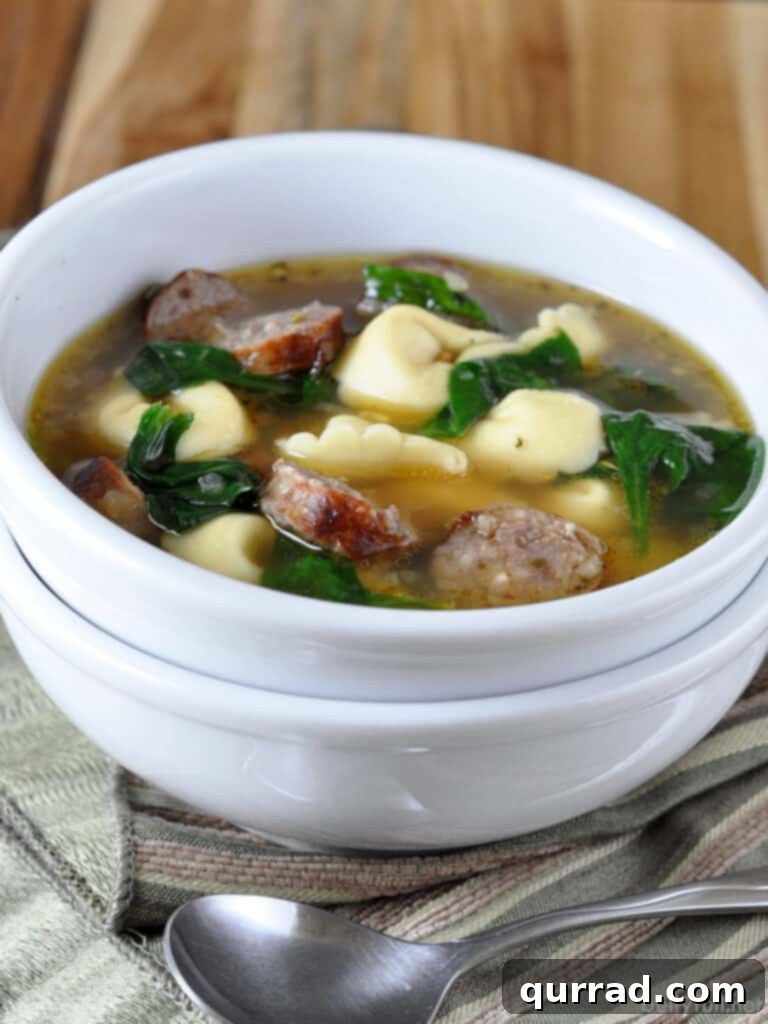 Creamy Sausage Tortellini Comfort 2 White bowl brimming with savory Sausage Tortellini Soup, featuring rich broth, plump tortellini, and tender spinach