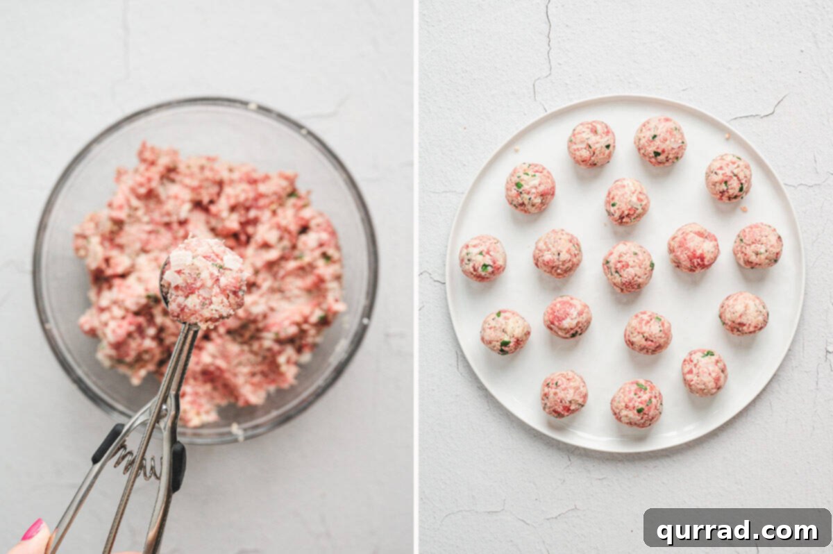 A hand using a cookie scoop to perfectly form uniform homemade Italian Meatballs.