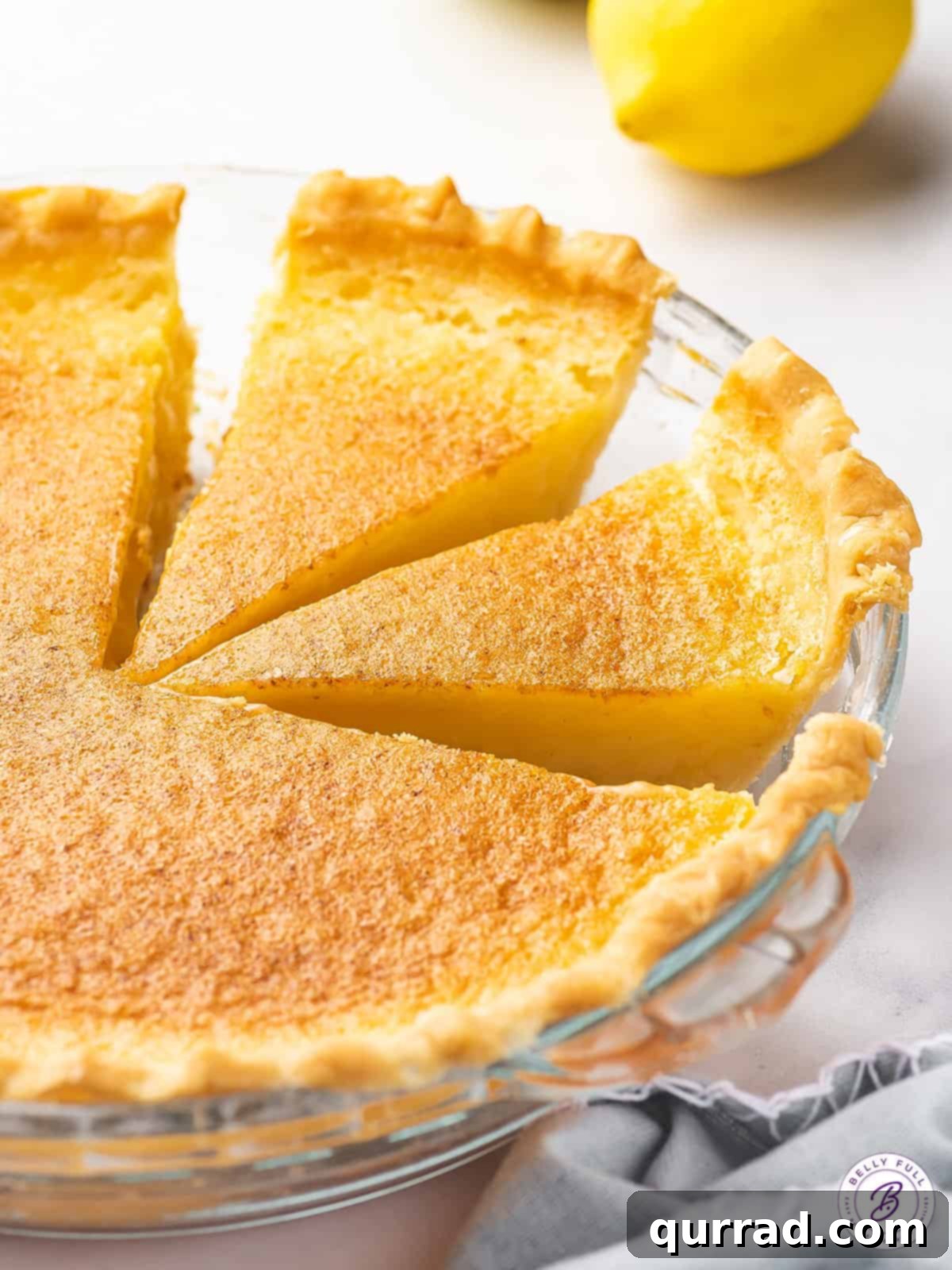 Side view of a vibrant Lemon Curd Pie with two perfect slices ready to be served