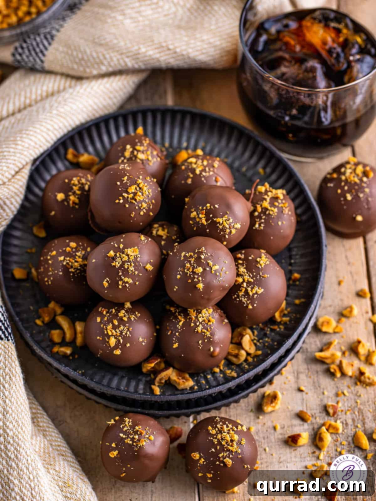 Kahlua Infused Chocolate Delights 3 Close-up of a pile of Kahlúa Chocolate Truffles, with scattered hazelnut crumbs, emphasizing their rich texture and perfect spherical shape.