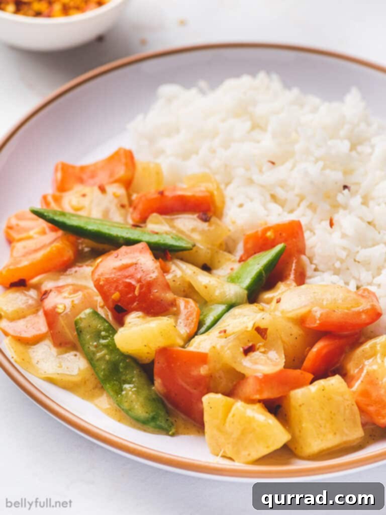 Effortless Veggie Wok 2 Close-up of a vibrant coconut curry vegetable stir fry served on a plate with fluffy white rice, highlighting the rich colors and textures of the dish.