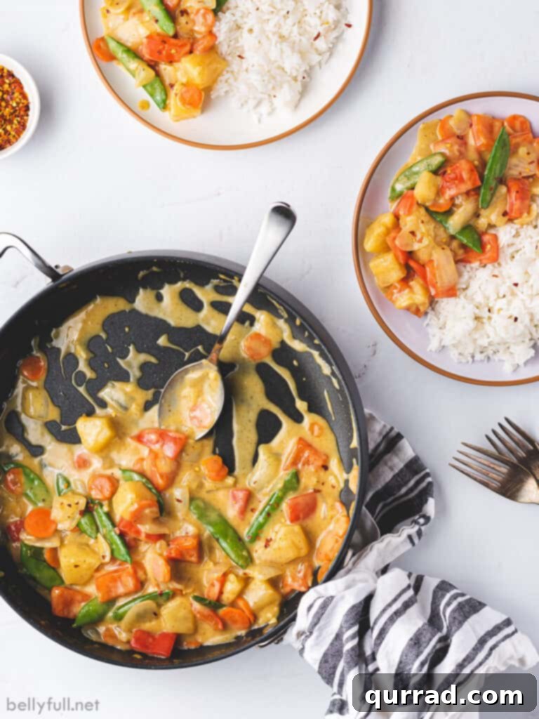 Effortless Veggie Wok 3 Overhead view of a colorful coconut curry vegetable stir fry simmering in a skillet, showcasing the mix of vegetables and the creamy sauce.