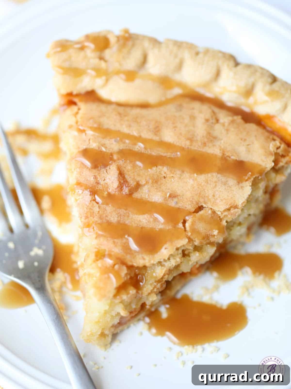 Decadent Macadamia Butterscotch Cookie Pie 3 Overhead view of a delectable slice of Macadamia Butterscotch Pie, adorned with a glossy caramel topping, highlighting its rich, inviting appearance.