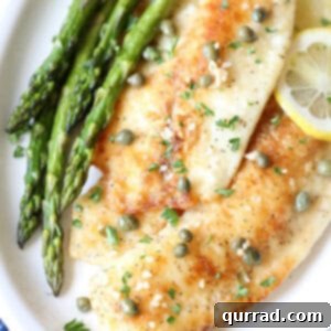 overhead fish piccata on plate with garlic and capers