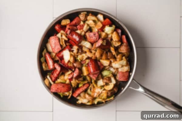 Overhead shot of the finished Kielbasa, cabbage, and potatoes dish perfectly mixed in a skillet, ready for serving.