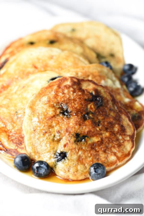Sweet Berry Clouds 2 blueberry oatmeal pancakes with syrup on white plate