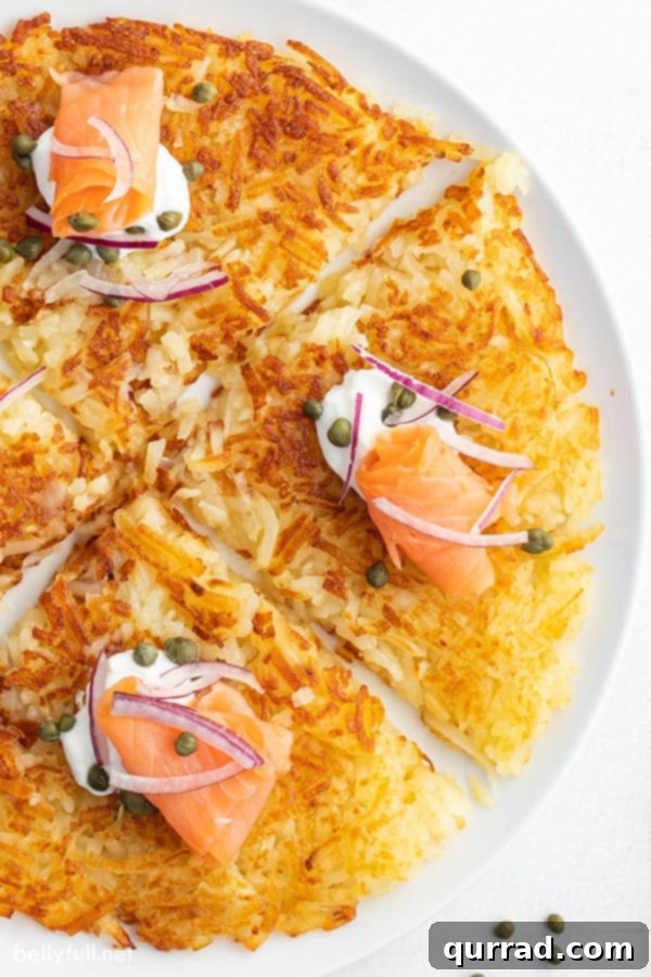 Close-up view of perfectly crispy homemade hash browns on a white plate, expertly cut into sections, ready to be enjoyed.