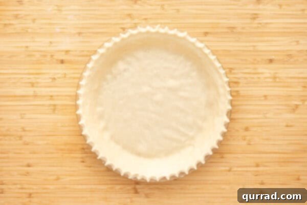 unbaked pie crust dough in pie plate with crimped edges