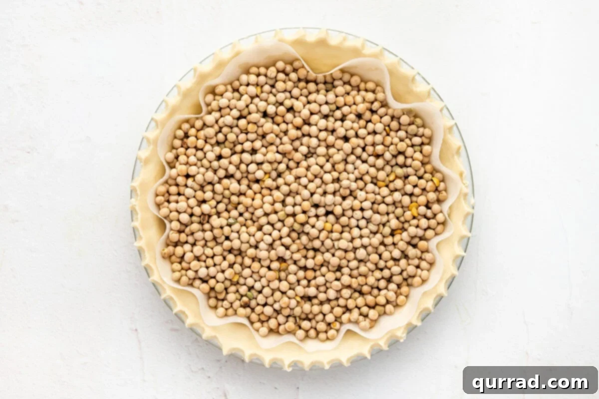 Perfect Homemade Pie Crust 6 unbaked pie crust with pie weights, ready for blind baking