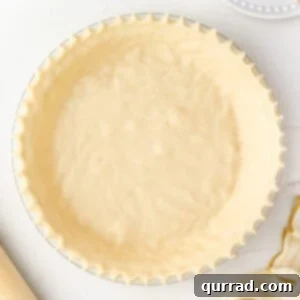 overhead unbaked pie crust with crimped edges