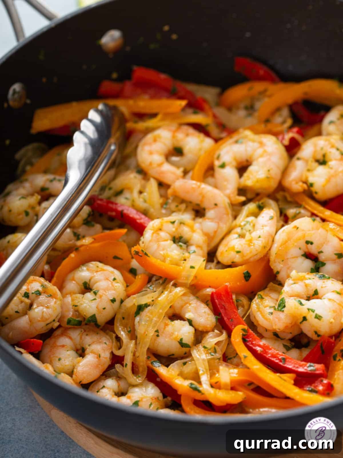 Sizzling Shrimp Fajitas 10 Sizzling shrimp fajitas in a cast iron skillet with tongs, ready to be served family-style.