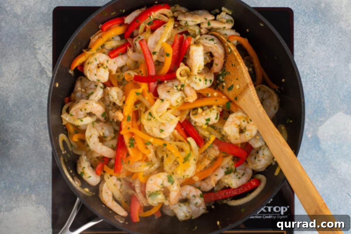 Sizzling Shrimp Fajitas 7 Seasoned shrimp added to the skillet with cooked peppers and onions, stirring to combine.