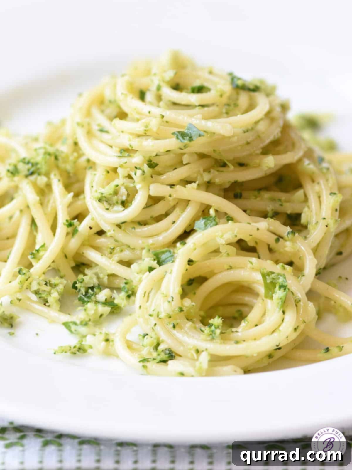 Emerald Broccoli Pesto Spaghetti 4 A generous mound of al dente cooked spaghetti, beautifully coated in vibrant broccoli pesto, ready for serving.