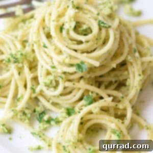 swirls of cooked spaghetti coated in broccoli pesto