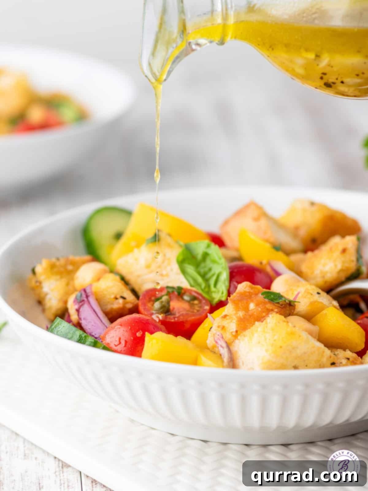 Panzanella: Tuscan Summer Tomato Bread Salad 4 vinaigrette being poured over salad