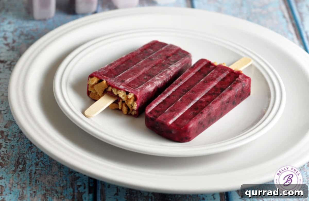 Creamy Blackberry Cheesecake Pops 3 Close-up of a single blackberry popsicle on a white plate, highlighting its smooth texture and rich purple hue.
