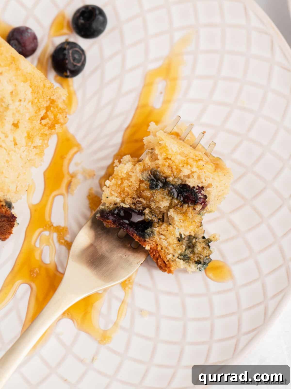 Fluffy Rice Cooker Pancakes 5 bite of blueberry pancake with syrup on top of fork