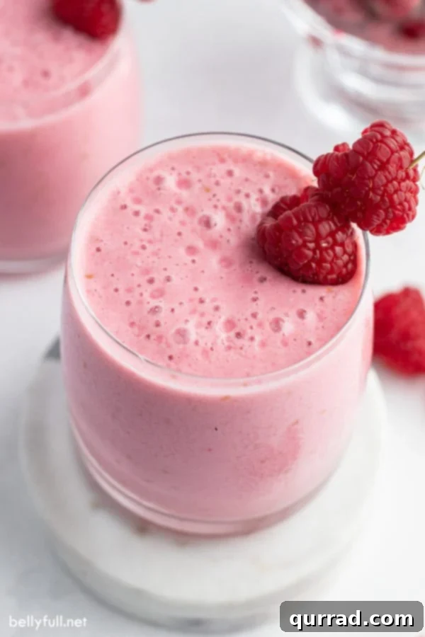 Refreshing Raspberry Lassi 2 raspberry lassi in glass with fresh raspberries as garnish
