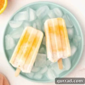 Overhead view of 2 orange creamsicles on a plate