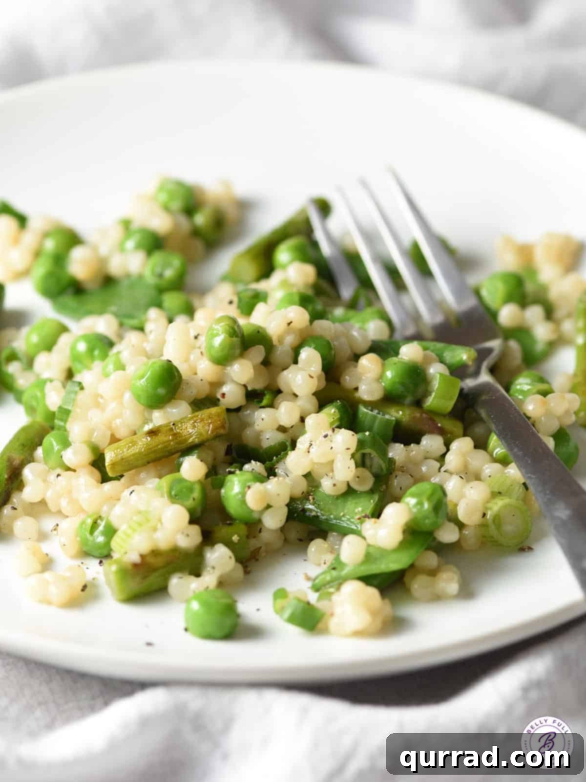 Spring Harvest Couscous 3 couscous with spring veggies and parmesan on a serving plate