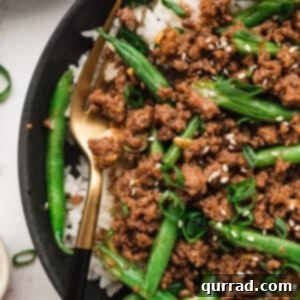 Korean ground beef and green beans over white rice in a bowl, ready to serve.