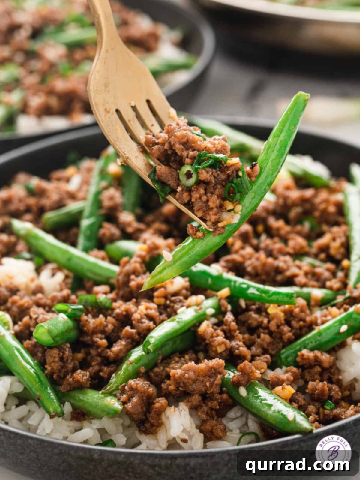 A close-up shot of cooked Korean ground beef and green beans neatly placed on a fork, ready to be enjoyed.