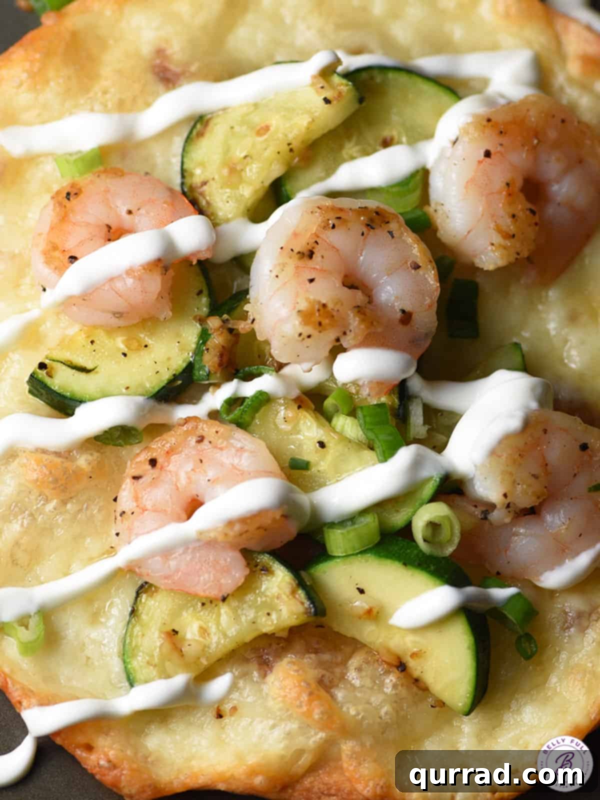 Zesty Shrimp & Zucchini Tostadas 4 Close-up of a stack of shrimp and zucchini tostadas, showing the melted cheese and fresh toppings.