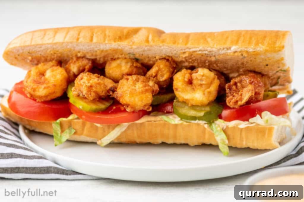 Crispy Shrimp Po Boy 4 fried shrimp foot long sandwich on white plate with remoulade sauce