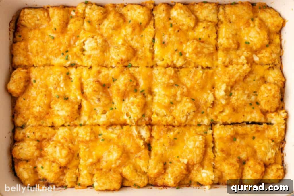 A large Tater Tot Breakfast Casserole in a baking dish, cut into neat squares, ready for serving.