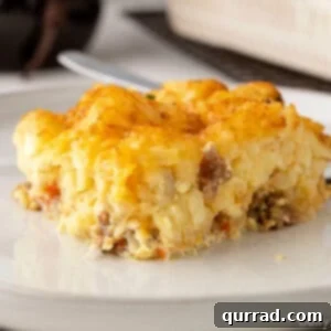 Square piece of Tater Tot Breakfast Casserole served on a plate, showing crispy tater tots and a rich egg filling.