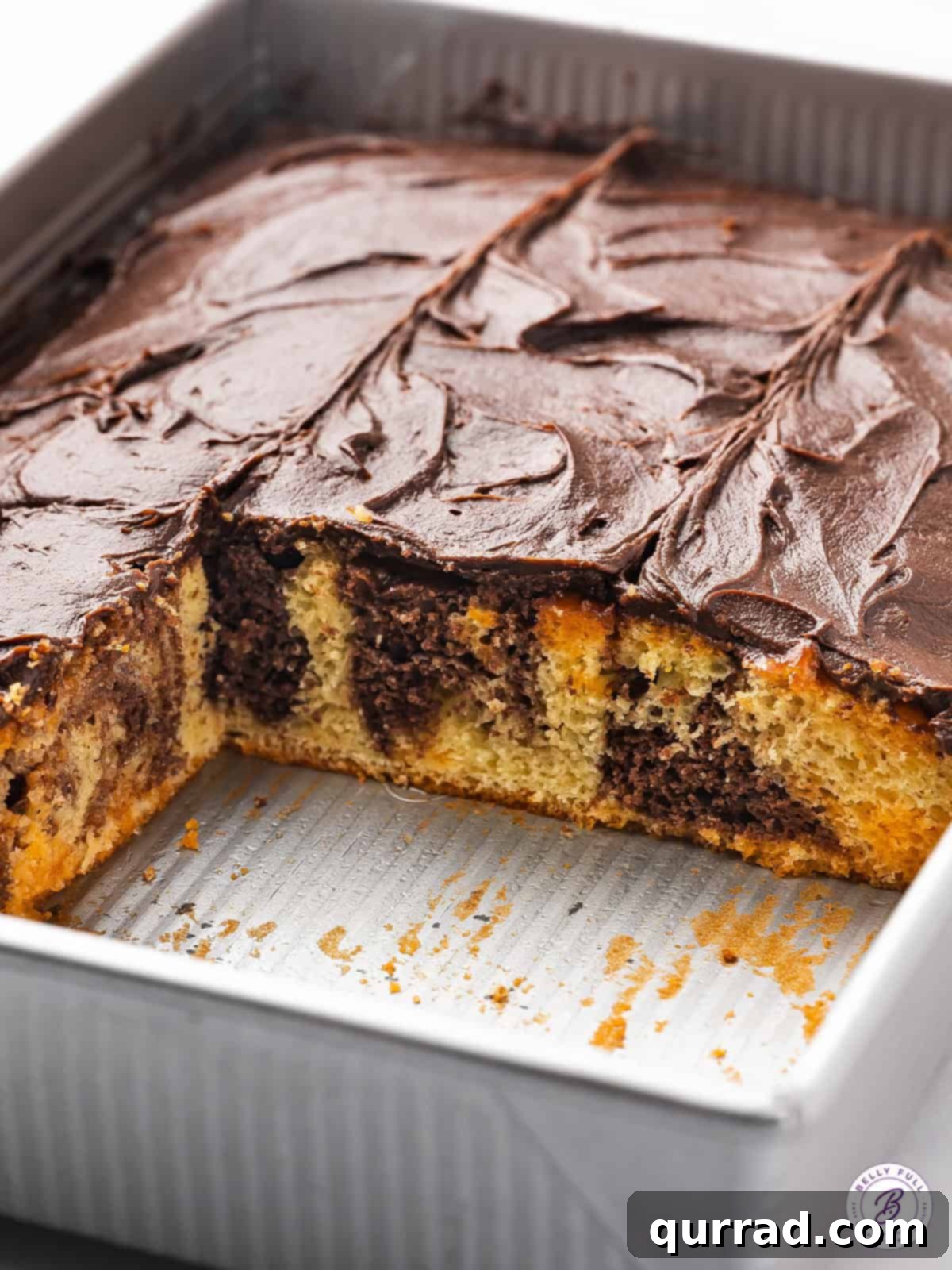 Witches' Brew Poke Cake 4 A whole frosted fudge marble cake in a baking dish, ready to be sliced and served.
